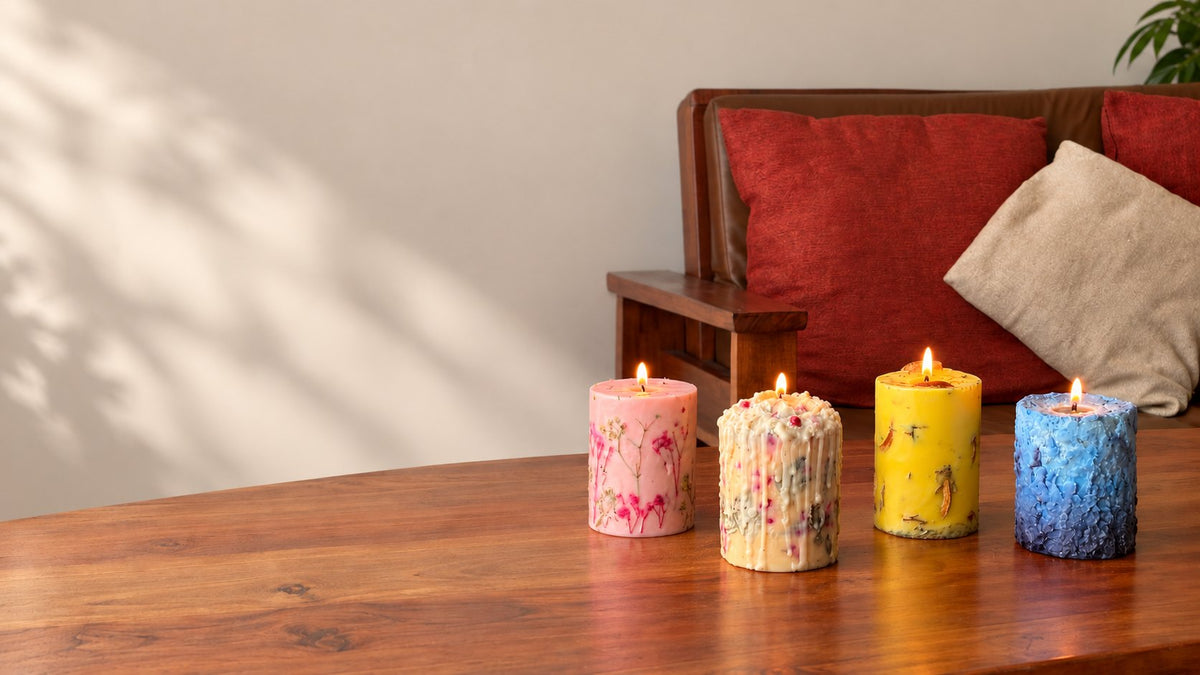 Four lit Ahoma candles on a wooden table, sofa behind